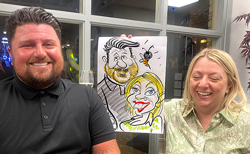 couple posing with caricature at brandshatch, kent couple at brandshatch posing with their caricature
