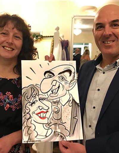 couple at leeford park hold their caricature