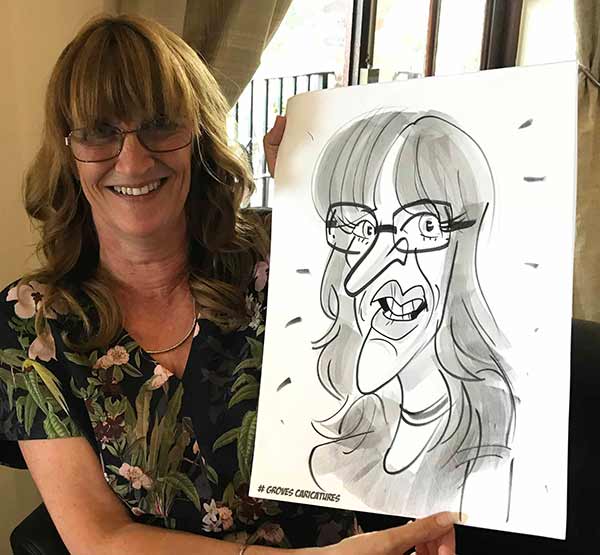 lady posing with her cartoon on the isle of wight guest posing with her caricature keepsake on the iOW