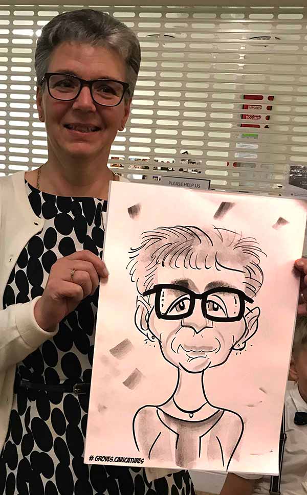 Lady poses with her caricature in reading woman really likes her caricature in Reading