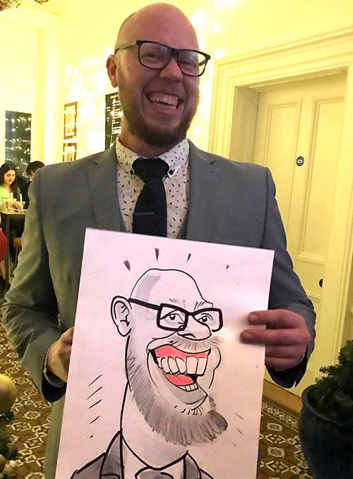 big teeth in caricature Bournemouth holding his caricature