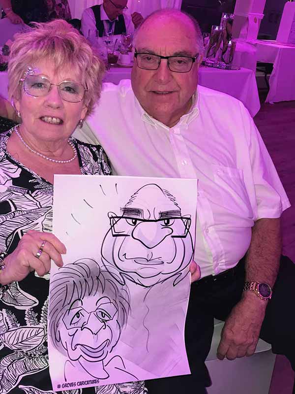 caricature artist draws at a portsmouth based party portsmouth couple hold their caricature up and smile