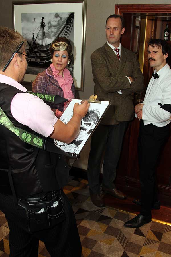 Caricaturist drawing Faulty Towers actors at a Faulty Towers Dinner Night