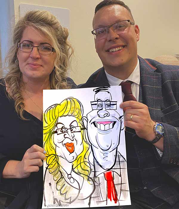Holiday Inn Caricature husband and wife pose for a photo with their caricature at Holiday inn